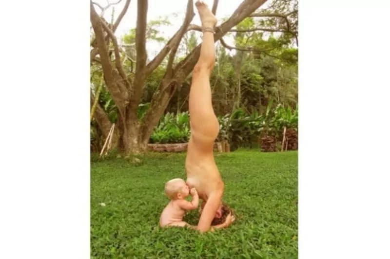 Mamma allatta nuda mentre fa yoga