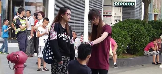 Incredibile ad Hong Kong: fidanzata gelosa fa inginocchiare il fidanzato per strada e lo picchia!!! [VIDEO]