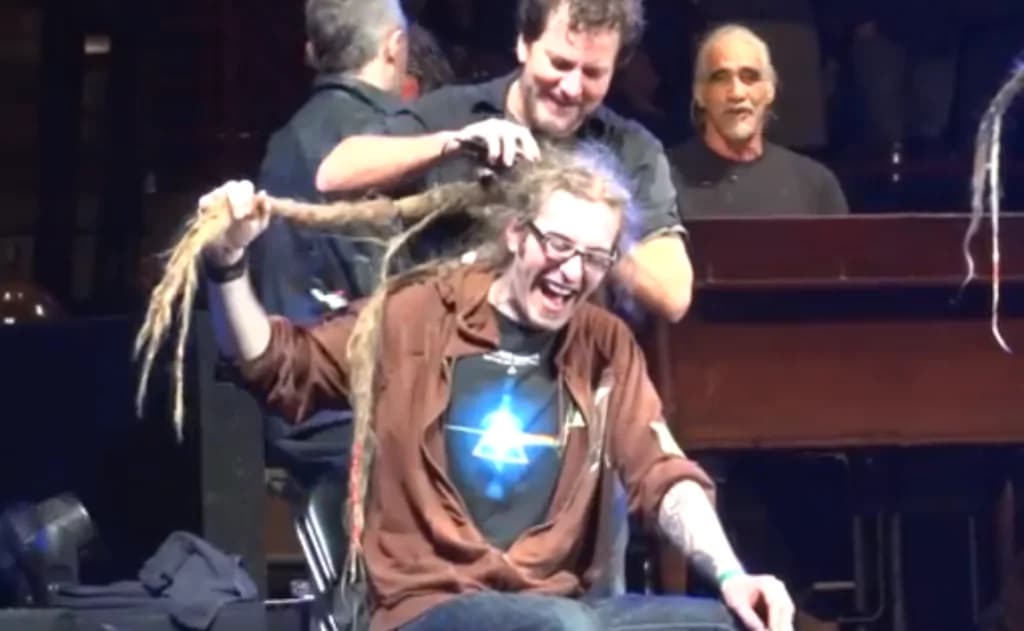 Perde una sfida con i Pearl Jam e si fa tagliare i lunghissimi dread sul palco (VIDEO)